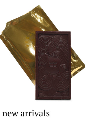 Dark chocolate bar with gold foil packaging on a white background