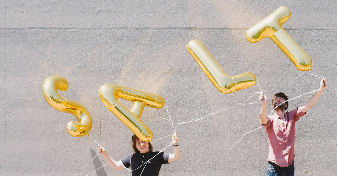 meadow staff holding up gold balloons that spell out SALT