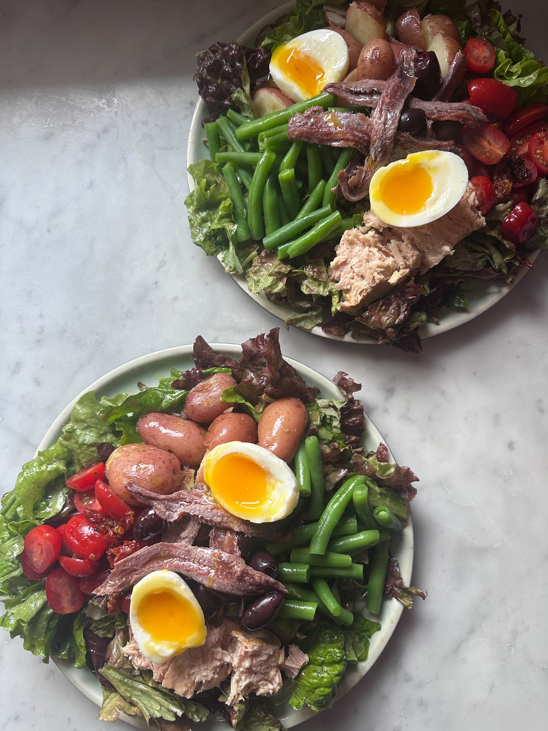 two salads on marble countertop