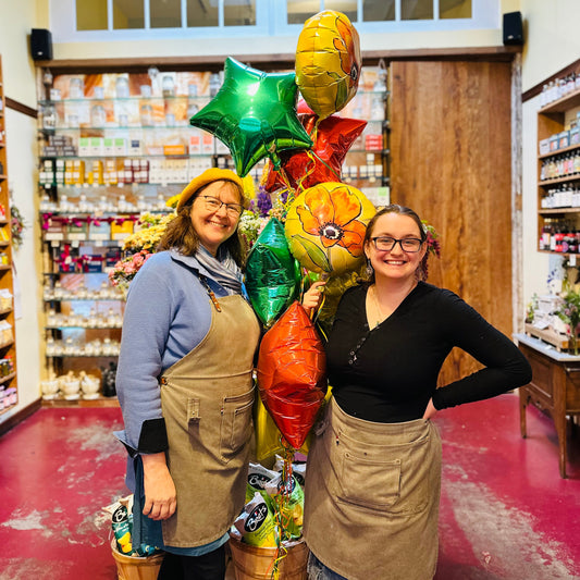 two shop keepers holding balloons