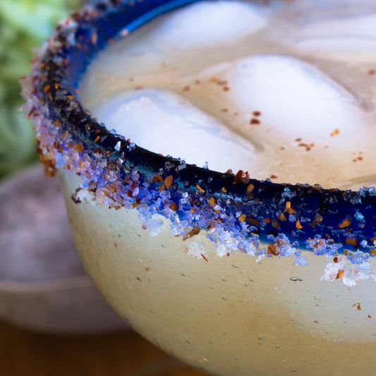 close up of margarita glass with a blue salted rim