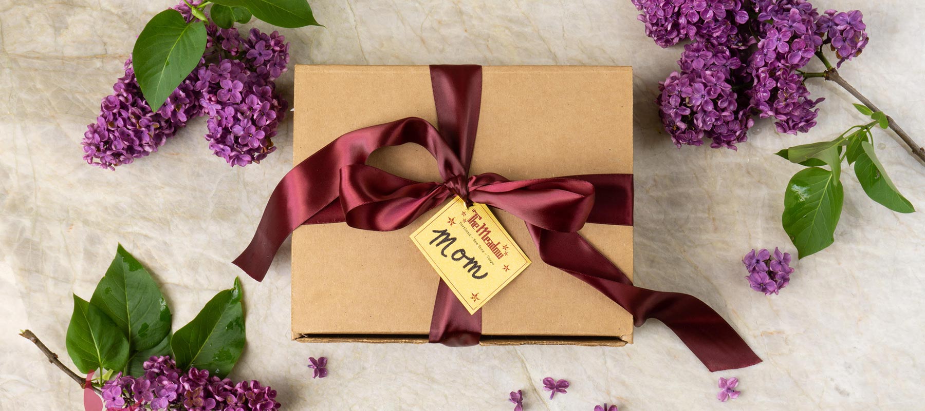 example spring gift box surrounded by lilacs