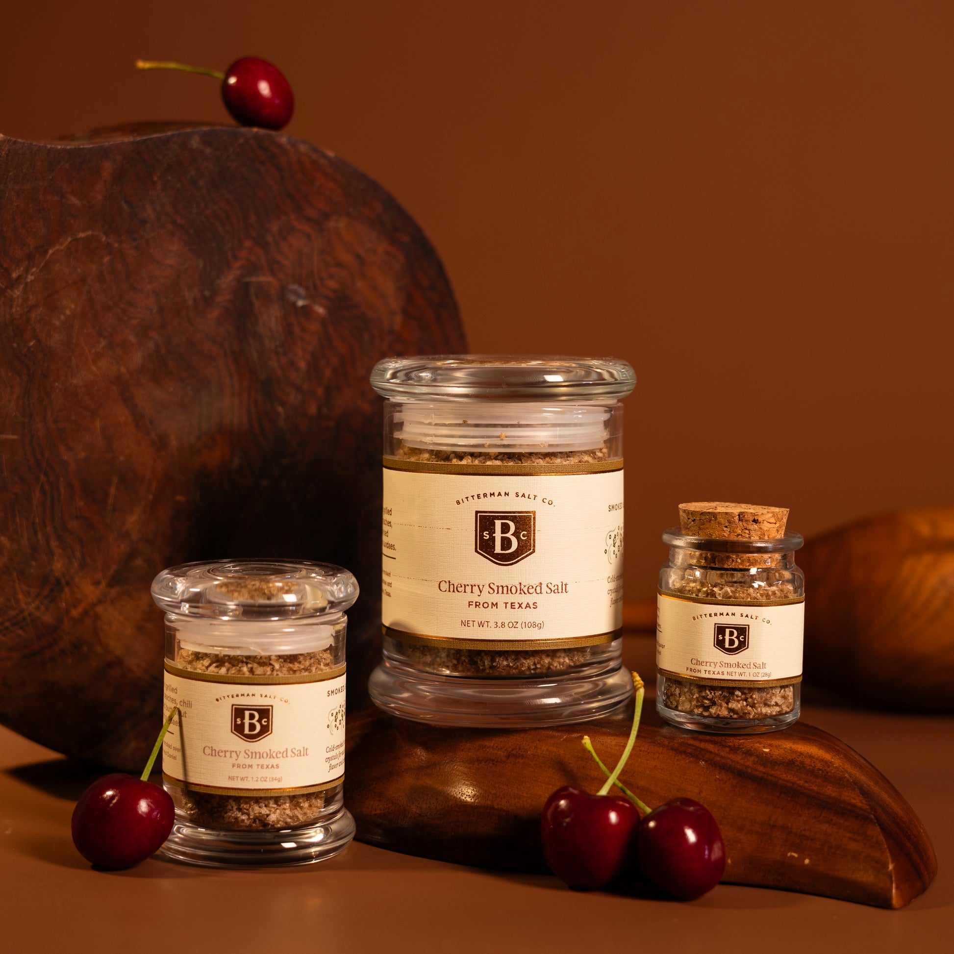 trio of three cherry smoked salts with wood and brown background