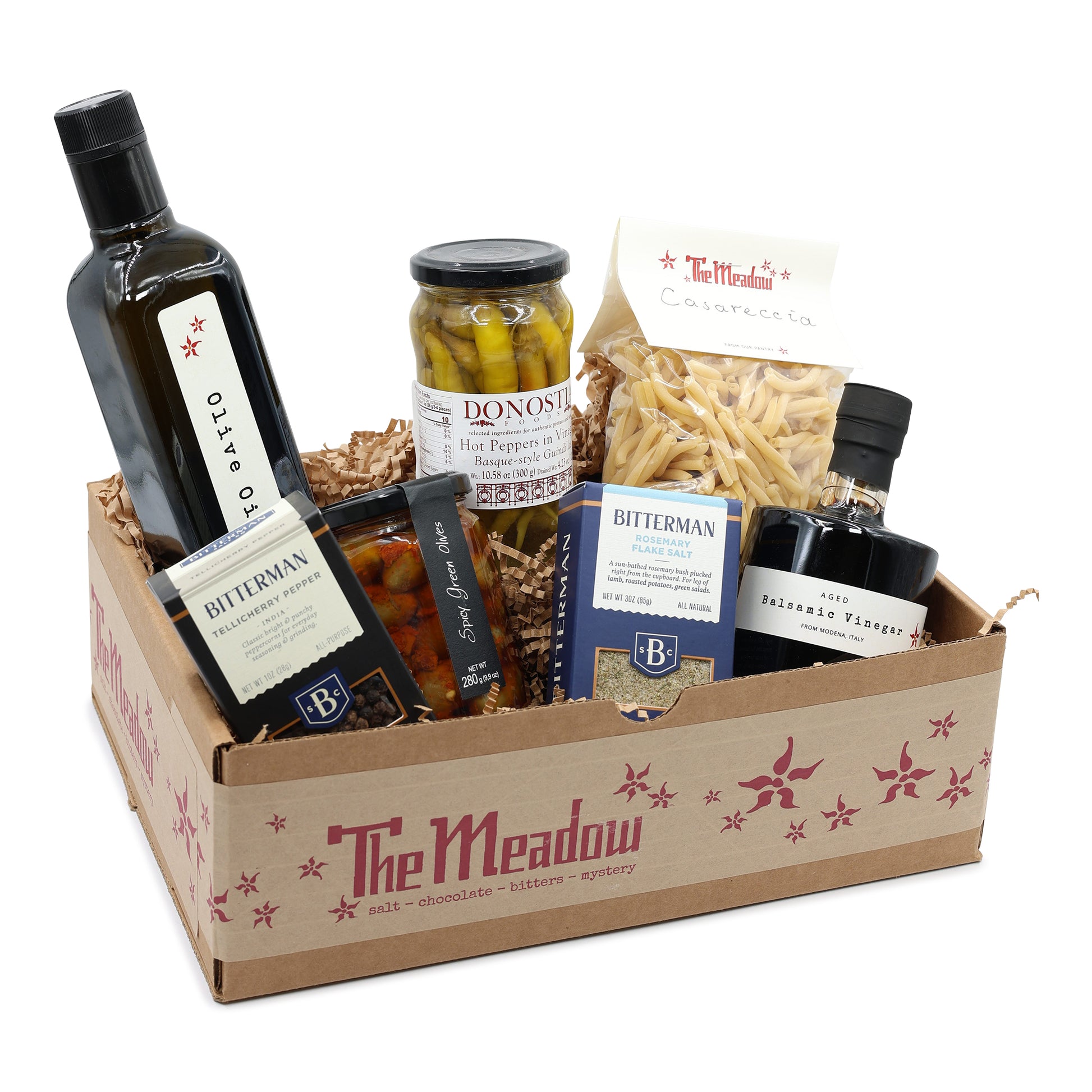 Gift basket from 'The Meadow' with various food items including a bottle of olive oil and a jar of pickles.