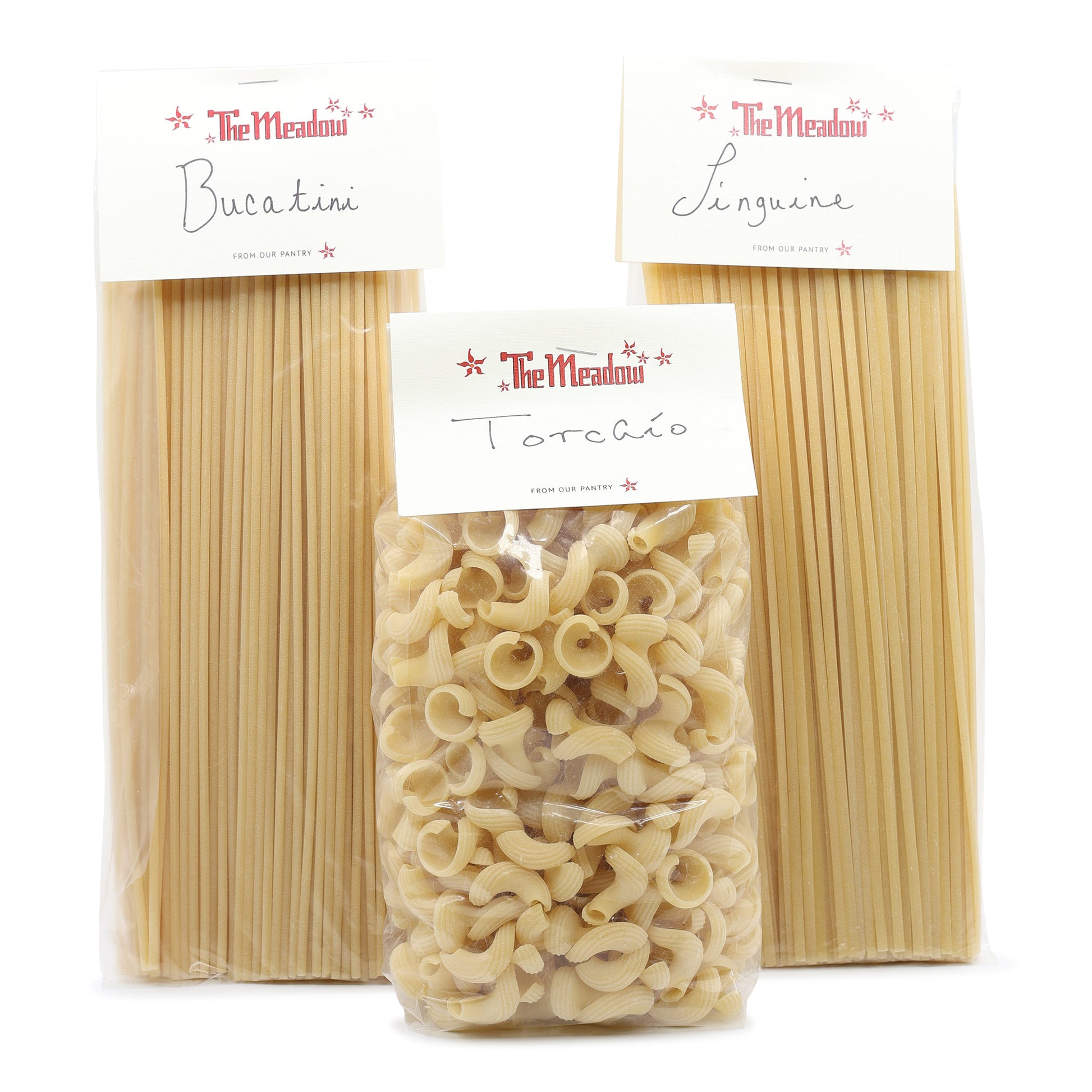 Three packages of pasta from The Meadow on a white background
