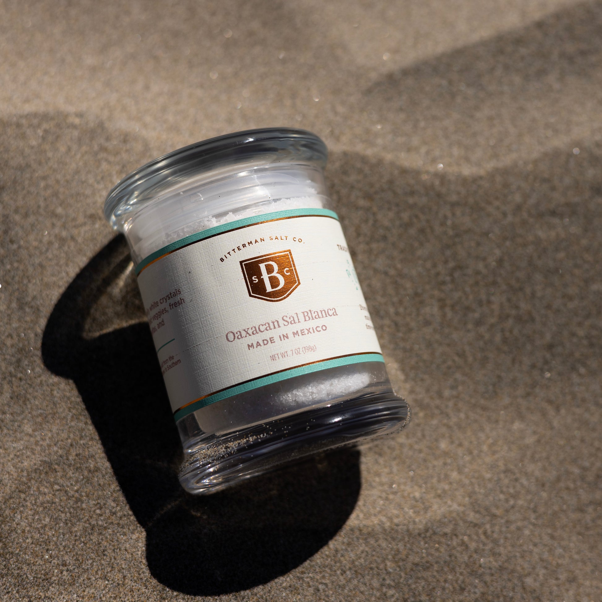 Jar of Oaxacan Sal Blanca on a sandy surface