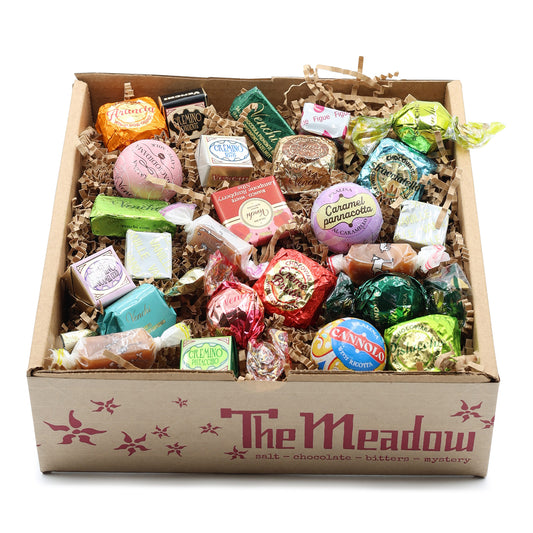 Assorted candies in a box labeled 'The Meadow' on a white background