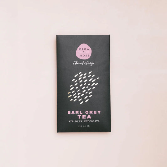 Dark chocolate bar packaging with 'Crow & Moss Chocolatery' branding on a light pink background