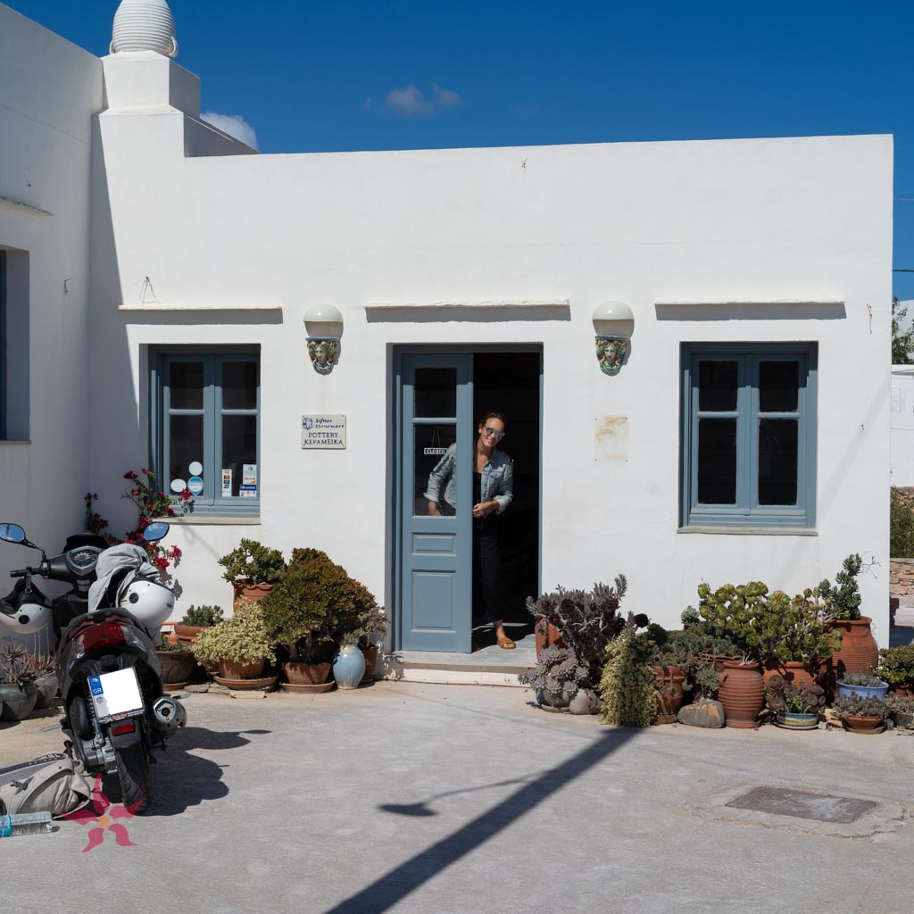 blue door with woman in doorway at sifnos stoneware on sifnos island, greece